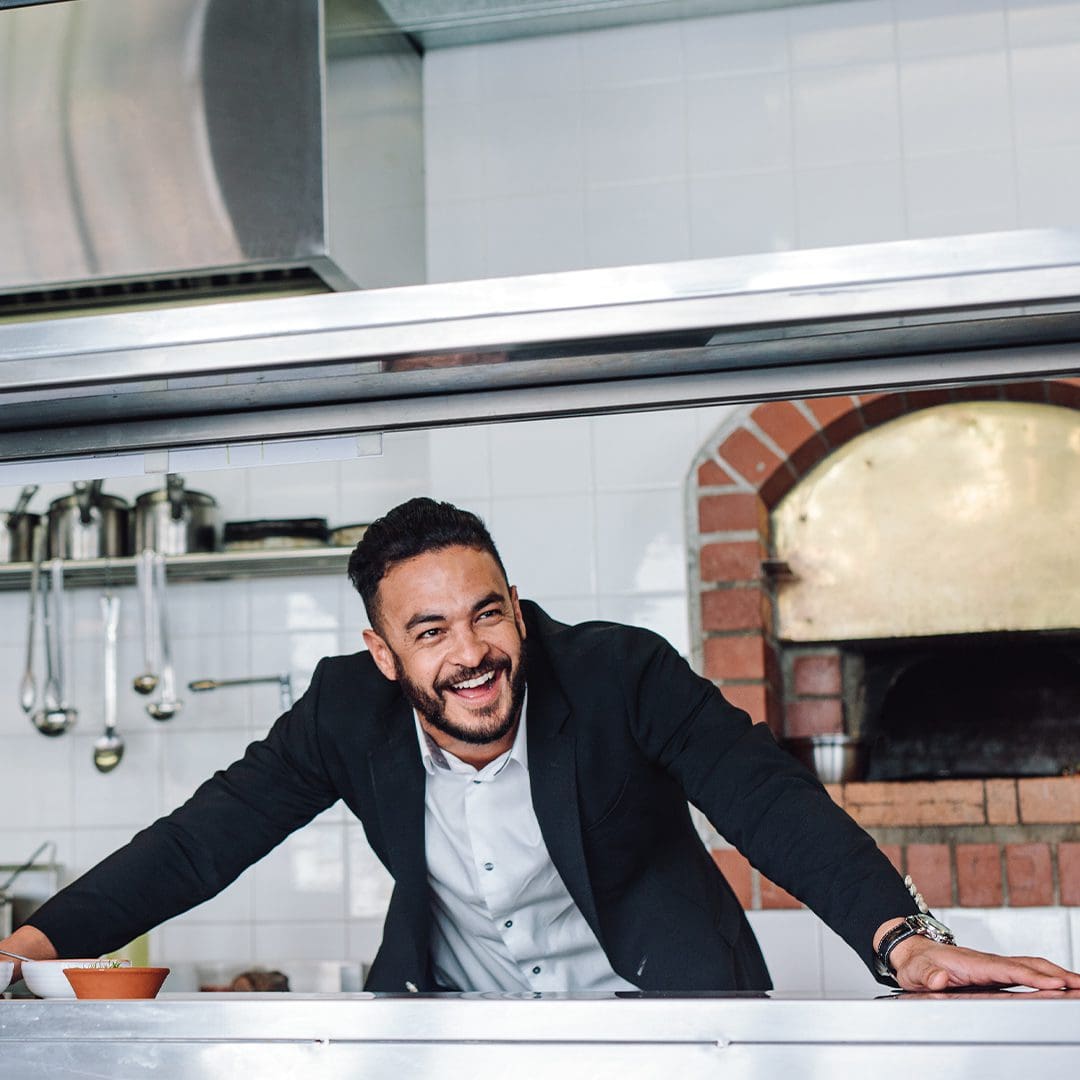 restaurant owner peeking through kitchen window