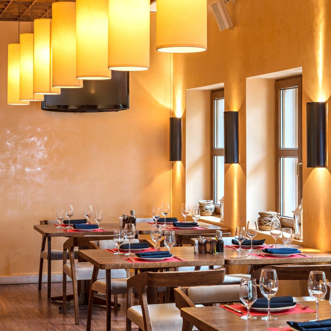 empty restaurant tables under modern pendant lights