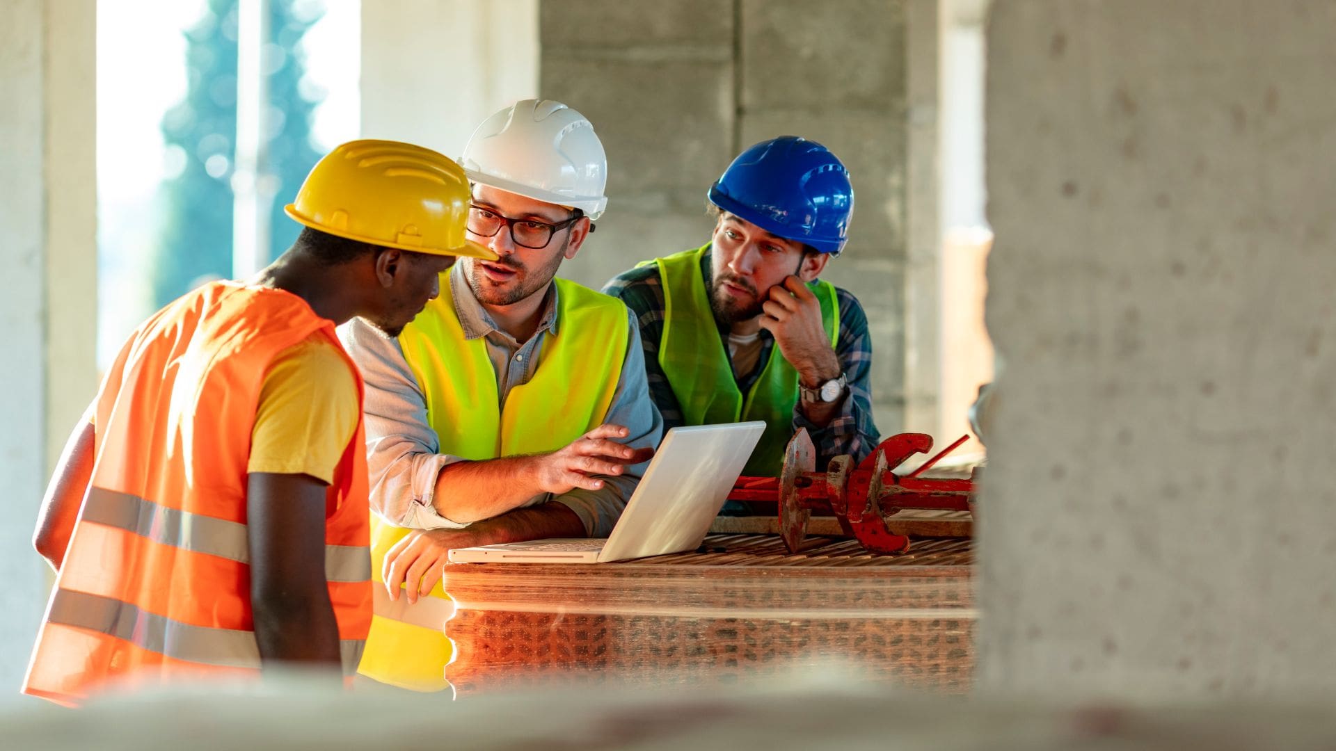 group of 3 construction workers reviewing a project