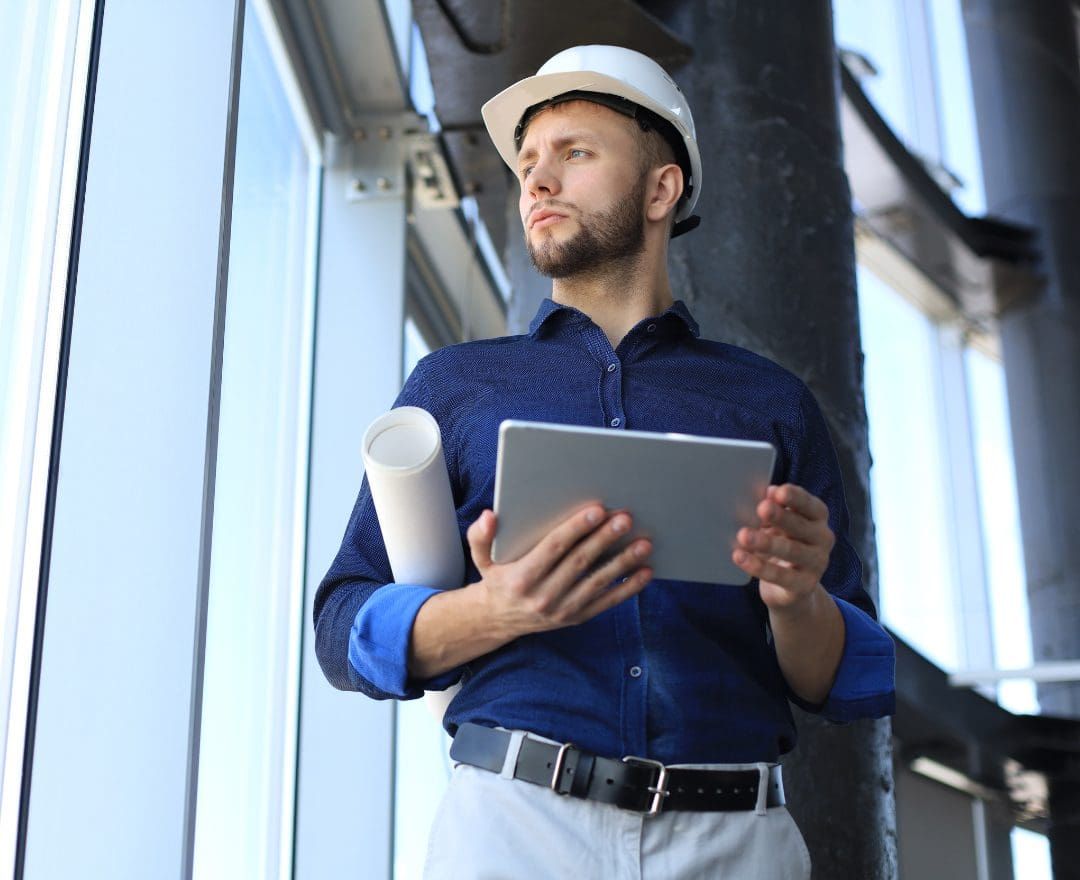 construction worker holding tablet and building plans
