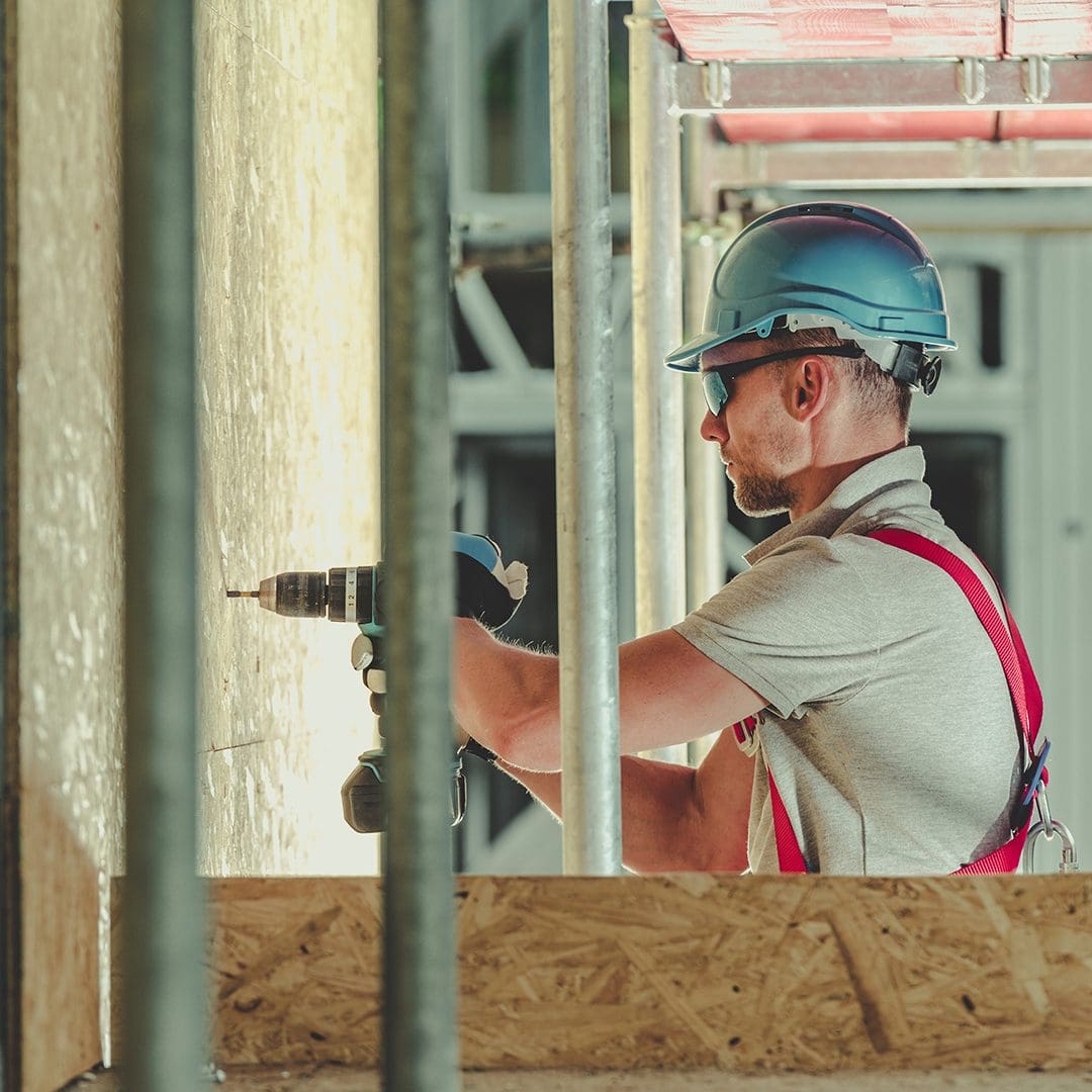 worker with safety equipment drilling