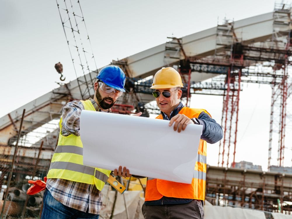 2 team members reading the construction blueprint